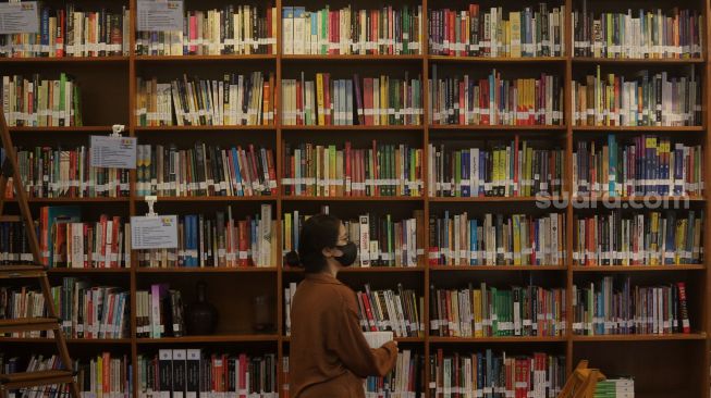 Pengunjung memilih buku untuk dibaca di perpustakaan "Baca Di Tebet", Jakarta, Rabu (25/5/2022). [Suara.com/Angga Budhiyanto]