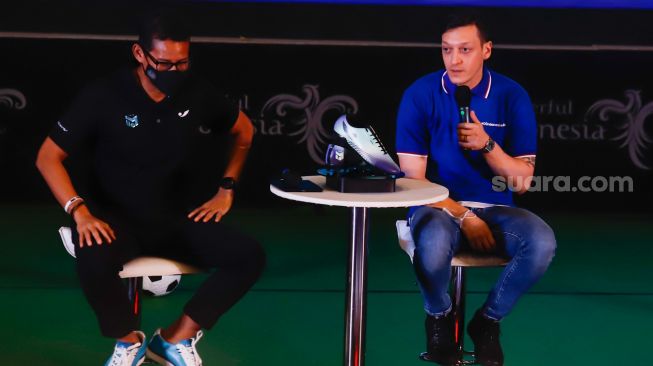 Pesepakbola Mesut Ozil (kanan) bersama Menteri Pariwisata, Ekonomi dan Kreatif (Meparekraf) Sandiaga Uno saat hadir dalam konferensi pers di Kementerian Pariwisata, Ekonomi dan Kreatif (Kemenparekraf), Jakarta Pusat, Rabu (25/5/2022). [Suara.com/Alfian Winanto]