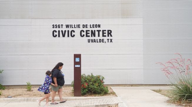 Anggota keluarga berkumpul di luar Ssgt Willie de Leon Civic Center, tempat para siswa dipindahkan dari Sekolah Dasar Robb setelah penembakan, di Uvalde, Texas, AS (24/5/2022).  allison / AFP