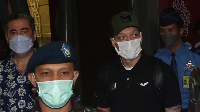 Mantan pesepak bola Timnas Jerman Mesut Ozil (kedua kanan) berjalan keluar setibanya di Bandara Soekarno Hatta, Tangerang, Banten, Selasa (24/5/2020).  ANTARA FOTO/Muhammad Iqbal