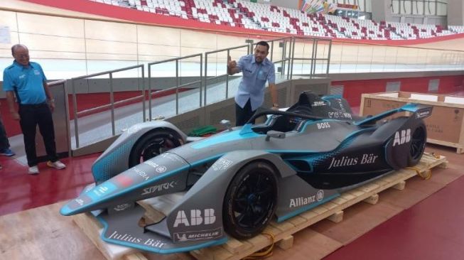 Ketua Panitia Pelaksana Formula E Jakarta Ahmad Sahroni memamerkan replika mobil balap Formula E di Jakarta International Velodrome, Rawamangun, Jakarta Timur, Kamis (26/5/2022). [Suara.com/Yaumal]