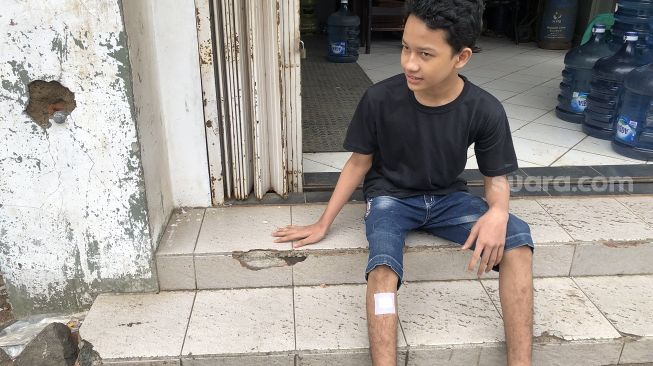 Pawitra (15) menunjukan lokasi pembegalan terhadap dirinya dan temannya di depan sebuah ruko di Duren Sawit, Jakarta Timur, Kamis (26/5/2022). [Suara.com/Faqih Fathurrahman]