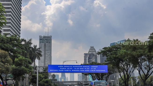 Sejumlah kendaraan melintas di Jalan Jenderal Sudirman Selatan, Jakarta Pusat, Jumat (27/5/2022). [Suara.com/Alfian Winanto]