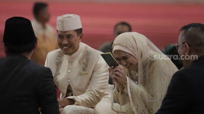 Artis Juliana Moechtar (kedua kanan) didampingi suami Letkol Inf Nur Wahyudi (kedua kiri) menerima buku nikah saat akad nikah di Masjid Istiqlal, Jakarta, Jumat (27/5/2022). [Suara.com/Angga Budhiyanto]