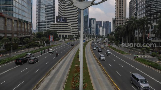 Sejumlah kendaraan melintas di Jalan Jenderal Sudirman Selatan, Jakarta Pusat, Jumat (27/5/2022). [Suara.com/Alfian Winanto]