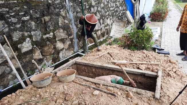 Sejumlah petugas makam tengah menggali liang lahat untuk almarhum Buya Syafii di TPU Husnul Khotimah, Donomulyo, Kapanewon Nanggulan, Kulon  Progo, Jumat (27/5/2022). [Muhammad Ilham Baktora / SuaraJogja.id]