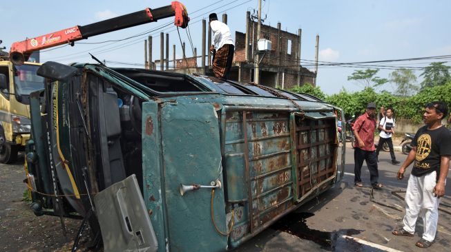 Warga melihat mobil minibus yang mengalami kecelakaan di Kampung Boru Jalan Syekh Nawawi Kota Serang, Banten, Jumat (27/5/2022).  ANTARA FOTO/Asep Fathulrahman