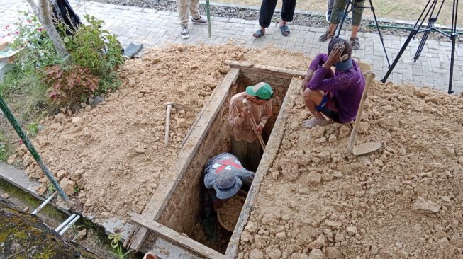 Sejumlah petugas makam tengah menggali liang lahat untuk almarhum Buya Syafii di TPU Husnul Khotimah, Donomulyo, Kapanewon Nanggulan, Kulon  Progo, Jumat (27/5/2022). [Muhammad Ilham Baktora / SuaraJogja.id]