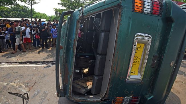 Warga melihat mobil minibus yang mengalami kecelakaan di Kampung Boru Jalan Syekh Nawawi Kota Serang, Banten, Jumat (27/5/2022).  ANTARA FOTO/Asep Fathulrahman