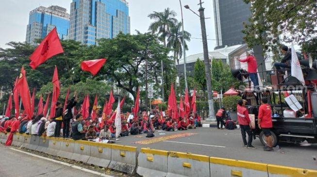 Ratusan massa buruh dari Federasi Perjuangan Buruh Indonesia (FPBI) menggelar aksi di kawasan Patung Kuda, Jakarta Pusat, Sabtu (28/5/2022). [Suara.com/Yosea Arga Pramudita]