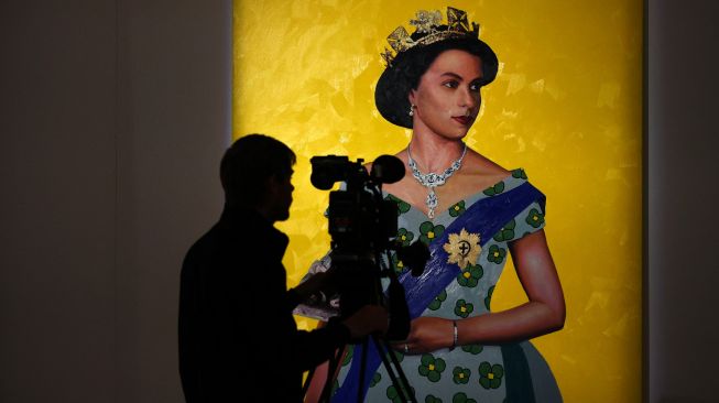 Seorang juru kamera merekam karya video "The Queen" (2022) oleh artis Nigeria Oluwole Omofemi saat sesi pemotretan untuk mempromosikan Sotheby's Jubilee Season, di London, Inggris, Jumat (27/5/2022). [ADRIAN DENNIS / AFP]
