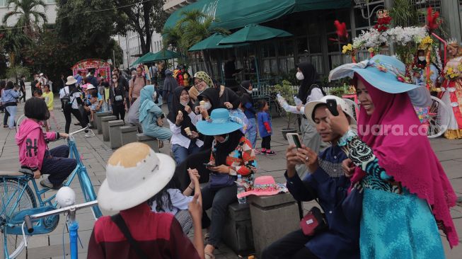 Warga berwisata di Taman Fatahillah, Kota Tua, Jakarta, Minggu (29/5/2022). [Suara.com/Angga Budhiyanto]