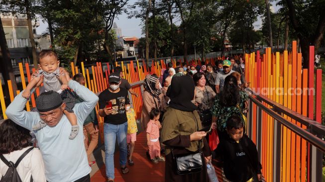 Warga melintasi jembatan Tebet Eco Park di Jakarta, Minggu (29/5/2022). [Suara.com/Angga Budhiyanto]