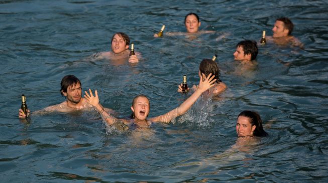 Pemuda Berenang di sungai Aare pada 21 Juni 2017 di Bern, Swiss. [AFP Photo]


