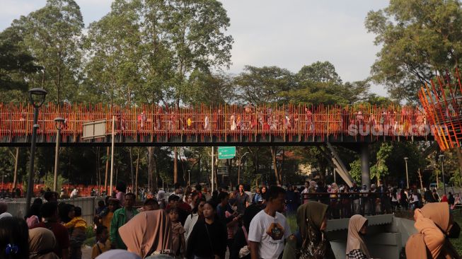 Warga melintasi jembatan Tebet Eco Park di Jakarta, Minggu (29/5/2022). [Suara.com/Angga Budhiyanto]