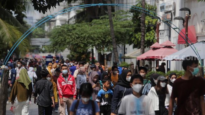 Warga berwisata di Taman Fatahillah, Kota Tua, Jakarta, Minggu (29/5/2022). [Suara.com/Angga Budhiyanto]