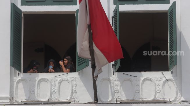 Warga berfoto di Museum Fatahillah, Kota Tua, Jakarta, Minggu (29/5/2022). [Suara.com/Angga Budhiyanto]