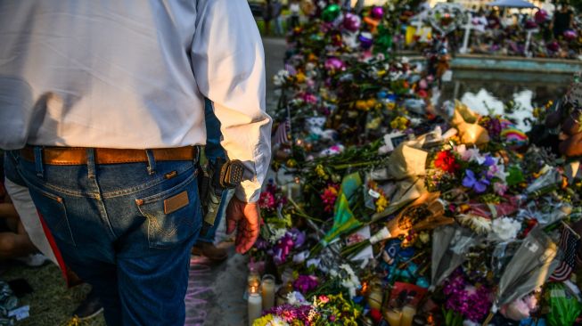 Bunga, mainan, dan sejumlah benda lain diletakkan di tugu peringatan untuk para korban penembakan sekolah yang mengakibatkan kematian 19 anak dan dua guru di Robb Elementary School, Uvalde, Texas, Amerika Serikat, Minggu (29/5/2022). . [AFP/Photo]
