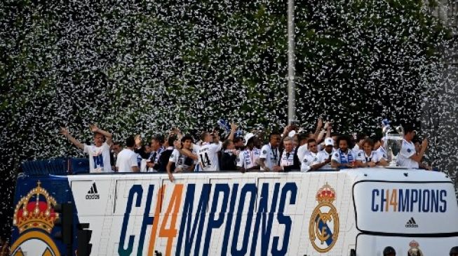 Para pemain Real Madrid merayakan sukses mereka meraih trofi Liga Champions dengan bus terbuka melalui jalan-jalan di kota Madrid pada 29 Mei 2022, sehari setelah mengalahkan Liverpool di final Liga Champions UEFA di Paris. GABRIEL BOUYS / AFP