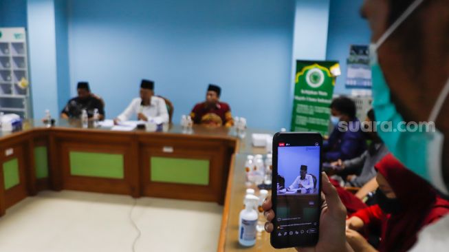 Ketua Komisi Fatwa MUI Asrorun Niam Soleh (tengah) saat memberikan keterangan pers terkait fatwa kurban ditengah wabah PMK di Gedung MUI Pusat, Jakarta Pusat, Selasa (31/5/2022). [Suara.com/Alfian Winanto]