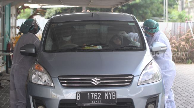 Petugas kesehatan melakukan swab PCR kepada warga di kawasan Cilandak, Jakarta Selatan, Selasa (31/5/2022). [Suara.com/Alfian Winanto]