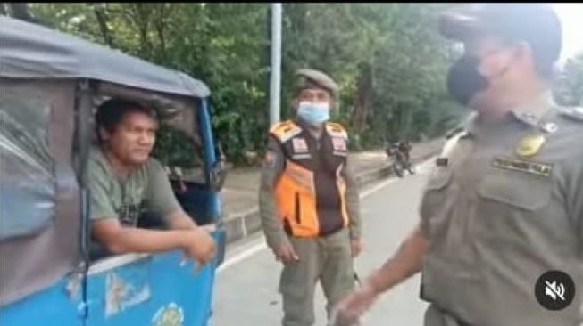 Petugas Satpol PP sedang menegur pengemudi Bajaj yang parkir sembarang di bahu jalan (Instagram/ @jurnalisjunior).