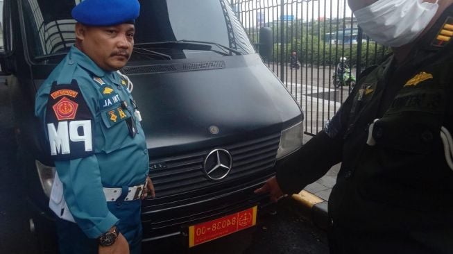 Pusat Polisi Militer (Puspom) TNI menderek kendaraan minibus mewah dengan plat dinas TNI yang sudah lama terparkir di kawasan pusat perbelanjaan di Kelapa Gading, Jakarta Utara, Selasa (31/5/2022). (Dokumentasi Puspom TNI)