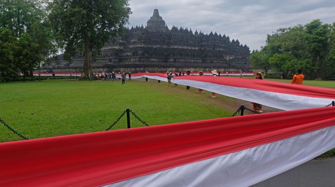 Peserta membentangkan bendera merah putih mengelilingi Candi Borobudur saat peringatan Hari Lahir Pancasila di Taman Wisata Candi (TWC) Borobudur, Magelang, Jawa Tengah, Rabu (1/6/2022). ANTARA FOTO/Anis Efizudin