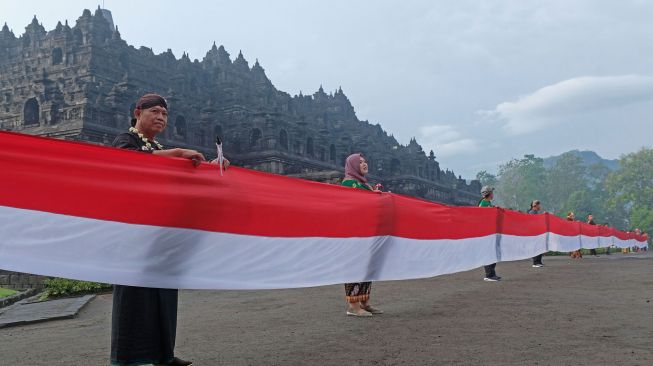 Peserta membentangkan bendera merah putih mengelilingi Candi Borobudur saat peringatan Hari Lahir Pancasila di Taman Wisata Candi (TWC) Borobudur, Magelang, Jawa Tengah, Rabu (1/6/2022). ANTARA FOTO/Anis Efizudin