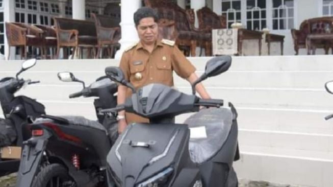 Bupati Buton, La Bakry menyerahkan lima unit motor listrik Gesits kepada ASN daerah itu, di Pasarwajo, Buton [Antara/HO].