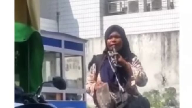 Tangkapan layar video viral pengamen berkerudung bersuara merdu. [Instagram]