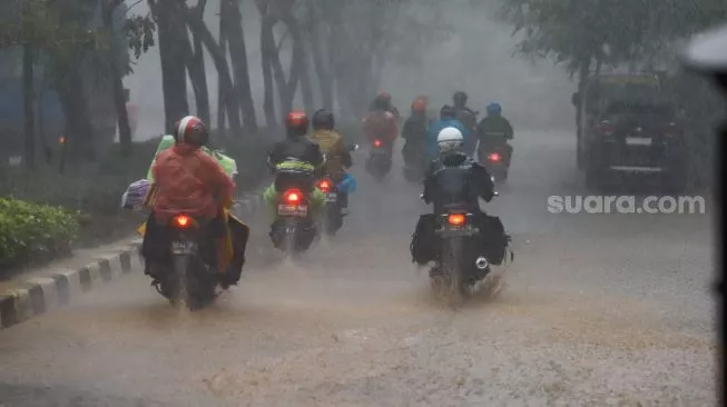 Sejumlah pengendara sepeda motor melintas saat hujan di Tanjung Priok, Jakarta Utara, Kamis (2/6/2022). [Suara.com/Alfian Winanto]