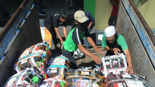 Petugas menurunkan koper milik jamaah calon haji di Asrama Haji Donohudan, Boyolali, Jawa Tengah, Kamis (2/6/2022).  ANTARA FOTO/Aloysius Jarot Nugroho