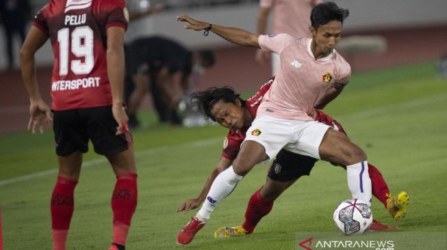 Pesepak bola Bali United Fahmi Al Ayyubi (tengah) berebut bola dengan pesepak bola Persik Kediri Dany Saputra (kanan) dalam laga pembuka Liga 1 2021-2022 di Stadion Utama Gelora Bung Karno (SUGBK), Senayan, Jakarta, Jumat (27/8/2021). [ANTARA FOTO/Aditya Pradana Putra/fo]