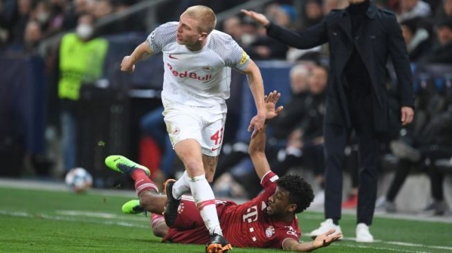 Bek sayap RB Salzburg Rasmus Kristensen (kiri) menjatuhkan pemain sayap Bayern Muenchen Kingsley Coman pada leg pertama babak 16 besar Liga Champions di Stadion Red Bull Arena, Salzburg, Austria. (16/2/2022). (ANTARA/REUTERS/ANDREAS GEBERT)