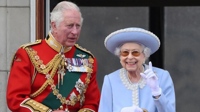 Ratu Inggris Elizabeth II dan Pangeran Charles Inggris menyaksikan atraksi pesawat khusus dari balkon Istana Buckingham saat perayaan 70 tahun tahta Ratu atau Queen Platinum Jubilee di London, Ingrris, Kamis (2/6/2022). [Daniel LEAL / AFP]
