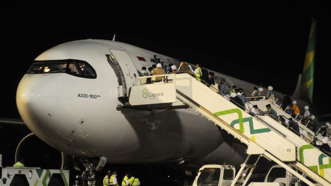 Jamaah calon haji kloter pertama antre memasuki pesawat saat keberangkatan di Bandara Adi Soemarmo, Boyolali, Jawa Tengah, Sabtu (4/6/2022) dini hari. [ANTARA FOTO/Aloysius Jarot Nugroho/nym]
