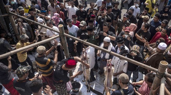 Sejumlah warga mengikuti lomba menguliti kambing dalam Lebaran Tenabang 2022 di depan Kantor Kecamatan Tanah Abang, Jakarta, Sabtu (4/6/2022).  ANTARA FOTO/Aprillio Akbar