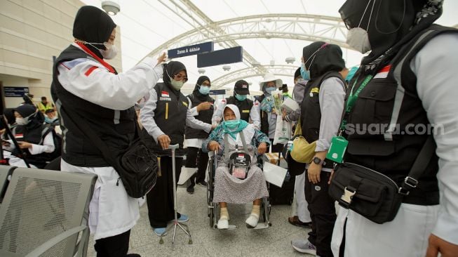 Petugas Panitia Penyelenggara Ibadah Haji (PPIH) menyambut jamaah calon haji kloter pertama dari embarkasi Solo setibanya di Bandar Udara Internasional Amir Muhammad bin Abdul Aziz (AMMA), Madinah, Sabtu (3/6/2022). [ANTARA FOTO/HO/Media Center Haji 2022/aww]