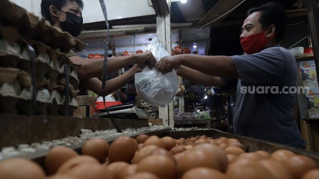 Pedagang telur melayani pembeli di salah satu kios di Pasar Minggu, Jakarta, Minggu (5/6/2022). [Suara.com/Angga Budhiyanto]