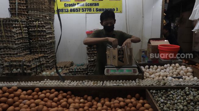 Pedagang mengemas telur ayam pesanan pembeli di salah satu kios di Pasar Minggu, Jakarta, Minggu (5/6/2022). [Suara.com/Angga Budhiyanto]