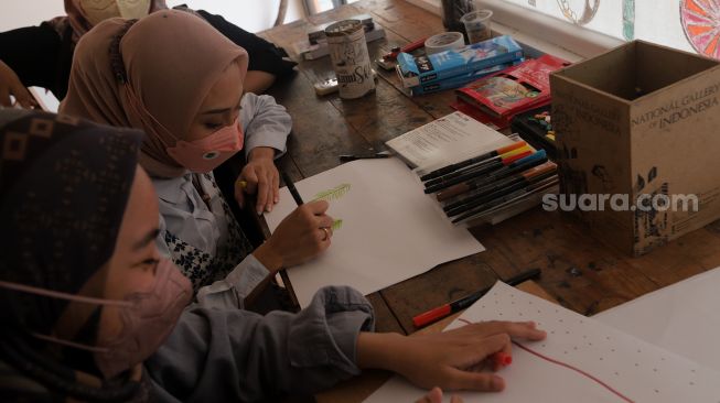 Pengunjung menggambar di area pameran sketsa "Rekonstruksi Kontrol Motorik" di Galeri Nasional, Jakarta, Minggu (5/6/2022). [Suara.com/Angga Budhiyanto]