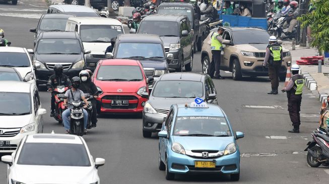Sejumlah polisi lalulintas memberhentikan pengendara mobil yang melanggar peraturan lalu lintas saat pemberlakuan aturan ganjil genap di Jalan Gajah Mada, Jakarta, Senin (6/6/2022).  ANTARA FOTO/Aditya Pradana Putra
