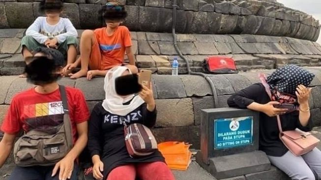 Wisatawan duduk dan panjat stupa Candi Borobudur walau sudah dilarang. (Twitter/@Wisata_IDN)