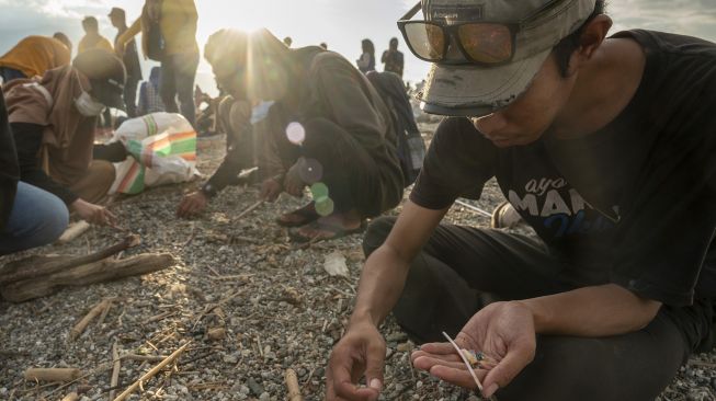 Sejumlah aktivis lingkungan mengambil sampel sampah plastik di Pantai Teluk Palu, Sulawesi Tengah, Minggu (5/6/2022).  ANTARA FOTO/Basri Marzuki
