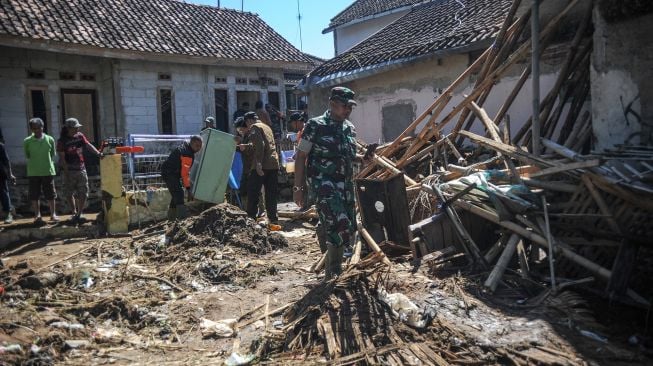 Anggota TNI dan relawan membantu menyelematkan berbagai barang milik warga pascabanjir bandang di Kampung Kaum Kidul, Ciwidey, Kabupaten Bandung, Jawa Barat, Selasa (7/6/2022). ANTARA FOTO/Raisan Al Farisi