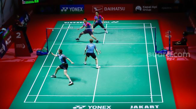 Pebulu tangkis ganda putra Indonesia Mohammad Ahsan dan Hendra Setiawan  melakukan serangan kepada pebulu tangkis ganda Denmark Jeppe Bay dan Lasse mohhede pada babak kualifikasi Daihatsu Indonesia Master 2022 di Istora Senayan,  Jakarta Pusat, Selasa (7/6/2022). [Suara.com/Alfian Winanto]