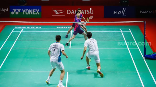 Pebulu tangkis ganda putra Indonesia Marcus Gideon dan Kevin Sanjaya melakukan serangan kepada pebulu tangkis ganda putra Prancis Christo Popov dan Toma Junior Popov pada babak kualifikasi Daihatsu Indonesia Master 2022 di Istora Senayan,  Jakarta Pusat, Selasa (7/6/2022). [Suara.com/Alfian Winanto]