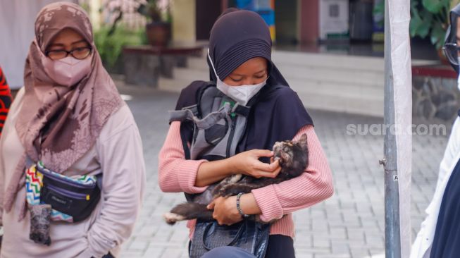 Warga membawa hewan peliharaannya untuk divaksin rabies di Kantor Kecamatan Duren Sawit, Jakarta Timur, Selasa (7/6/2022). [Suara.com/Alfian Winanto]