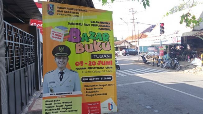 Pasang Banner Dipaku di Pohon, Dinas Perpustakaan dan Kearsipan Tuban 